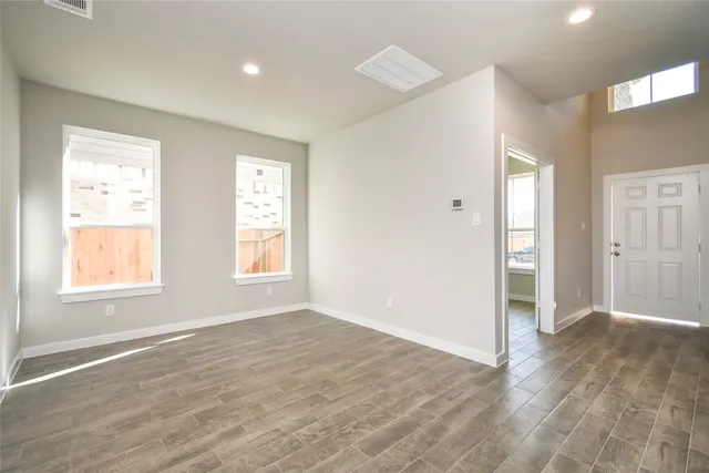 a view of a hallway with wooden floor and kitchen view