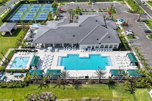 a view of a dining room with furniture a chandelier and large windows