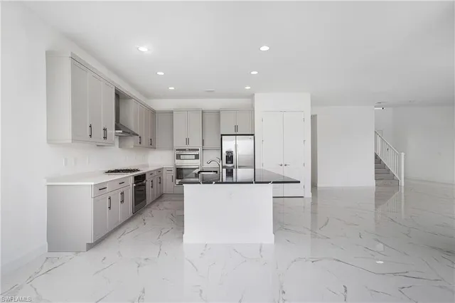 a large white kitchen with cabinets