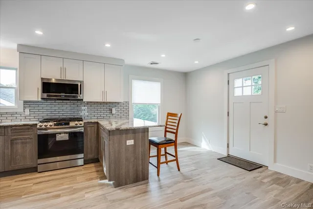 a kitchen with granite countertop a stove and a wooden floors