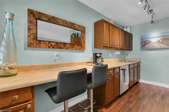a kitchen with a sink cabinets and wooden floor