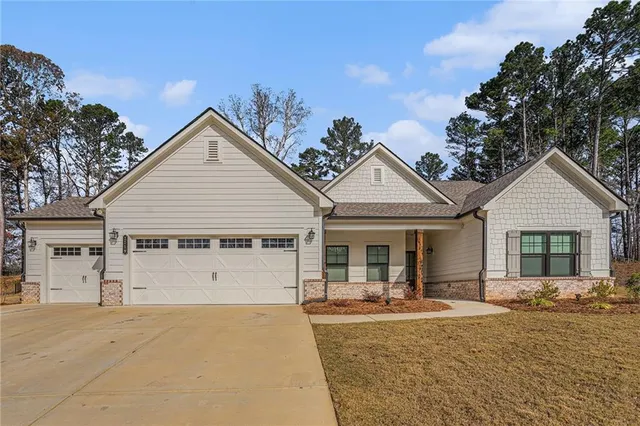 a view of a white house with a yard and potted plants