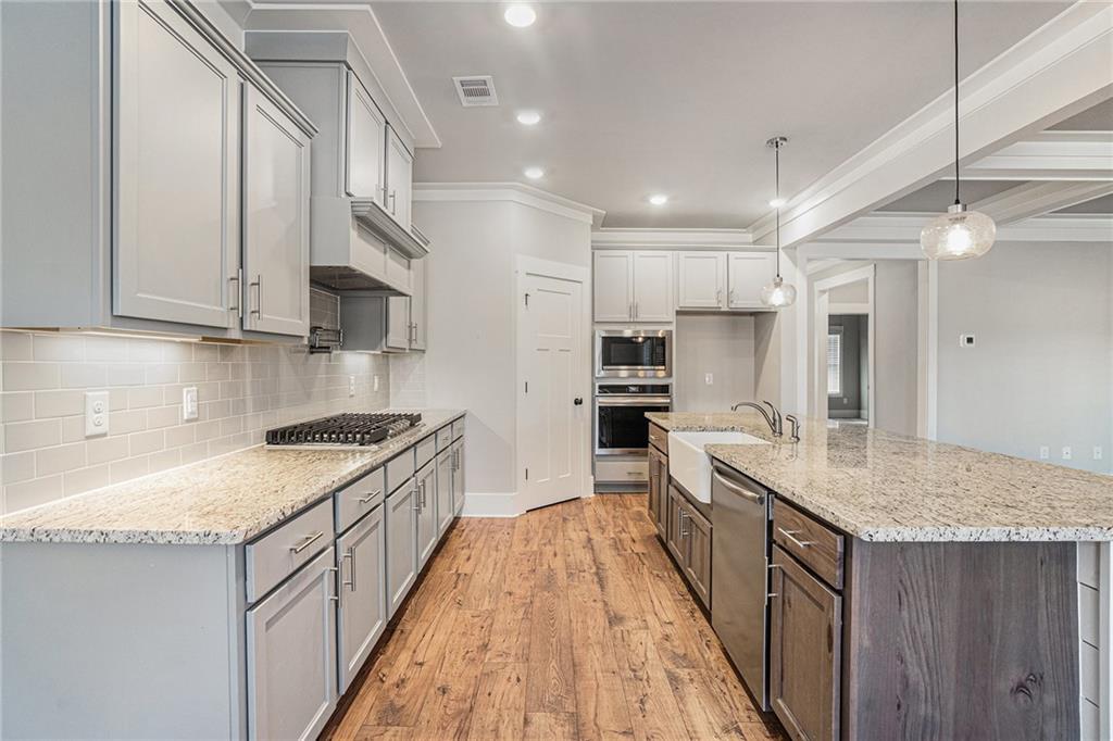 1119 Heights View Way Monroe, GA 30655 - Photo 11 of 30 a large kitchen with kitchen island a sink a stove a refrigerator and a wooden cabinets