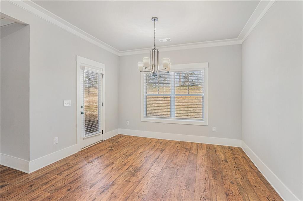 1119 Heights View Way Monroe, GA 30655 - Photo 12 of 30 an empty room with wooden floor cabinet and windows