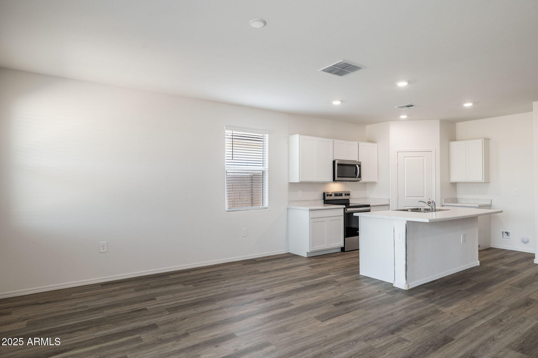 18401 West Hackamore Drive Wittmann, AZ 85361 - Photo 17 of 22 a kitchen with white cabinets and stainless steel appliances