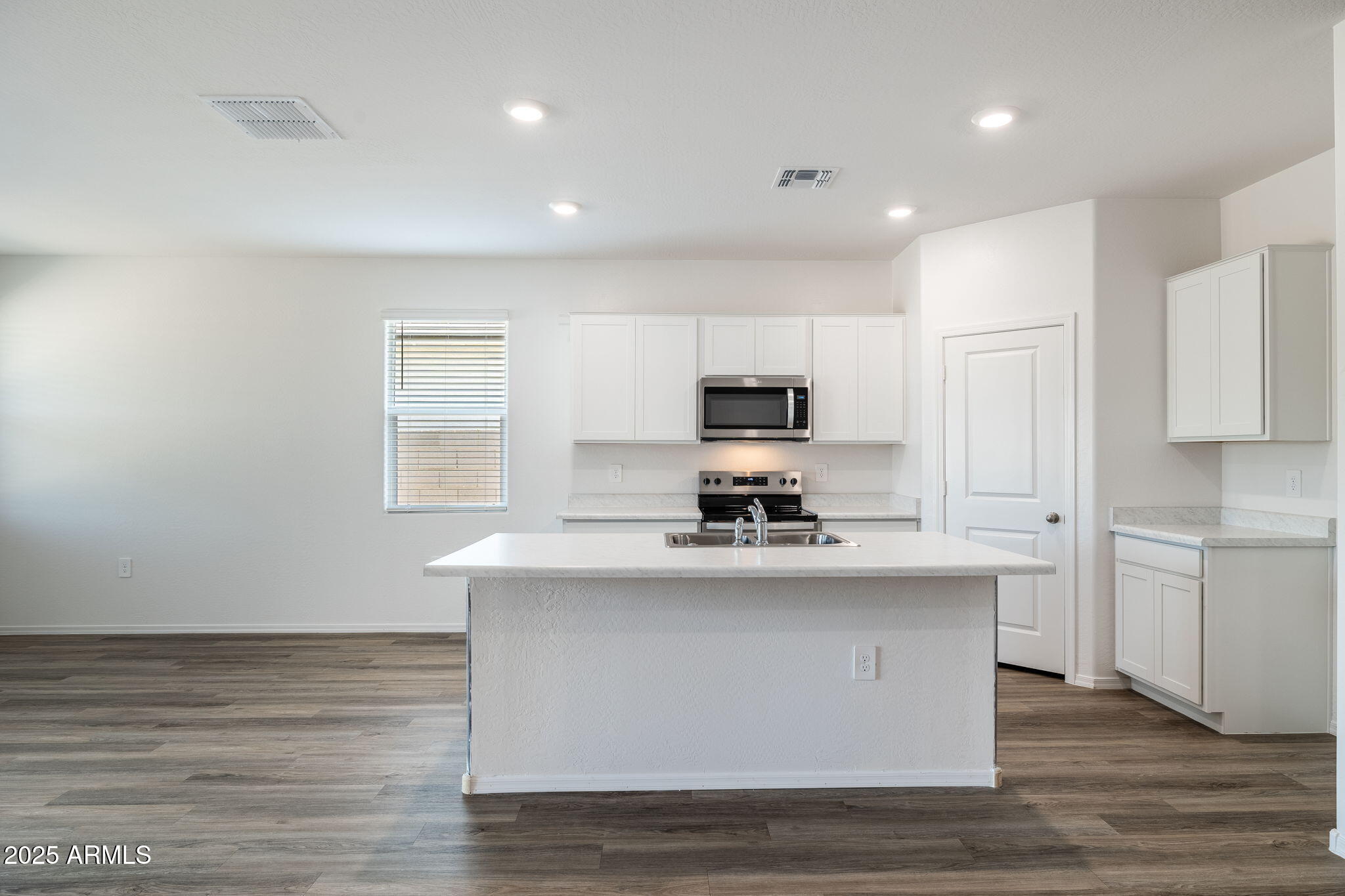 18401 West Hackamore Drive Wittmann, AZ 85361 - Photo 10 of 22 a kitchen with stainless steel appliances a sink a stove a microwave a center island and cabinets