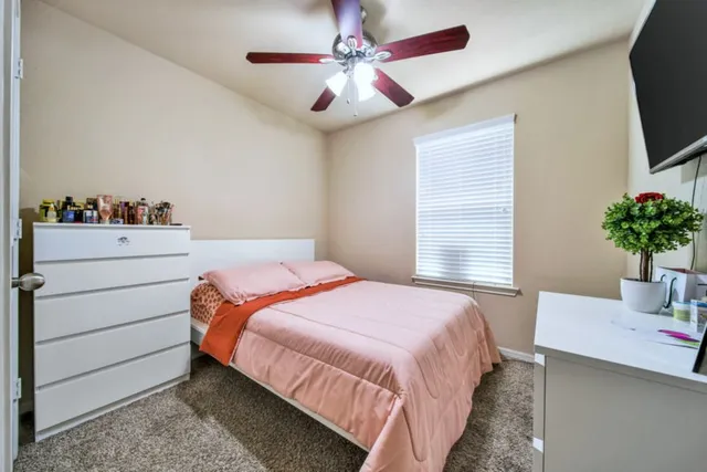 a bedroom with a bed and a potted plant