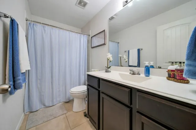 a bathroom with a double vanity sink toilet and a mirror