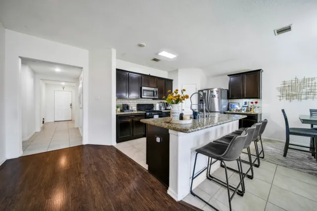 a kitchen with a sink cabinets and wooden floor