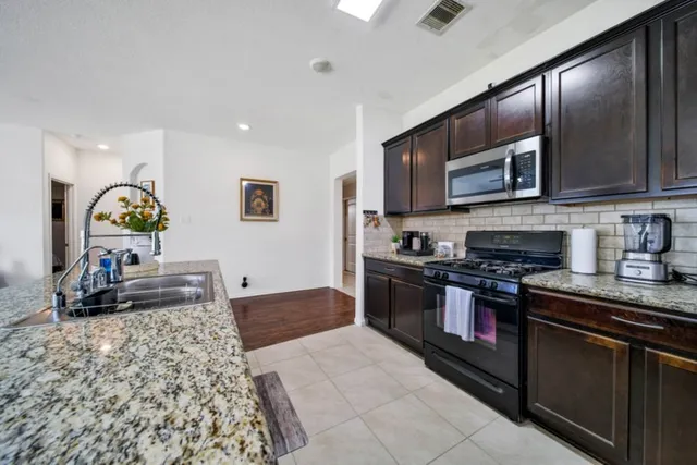 a kitchen with stainless steel appliances granite countertop a stove and a sink