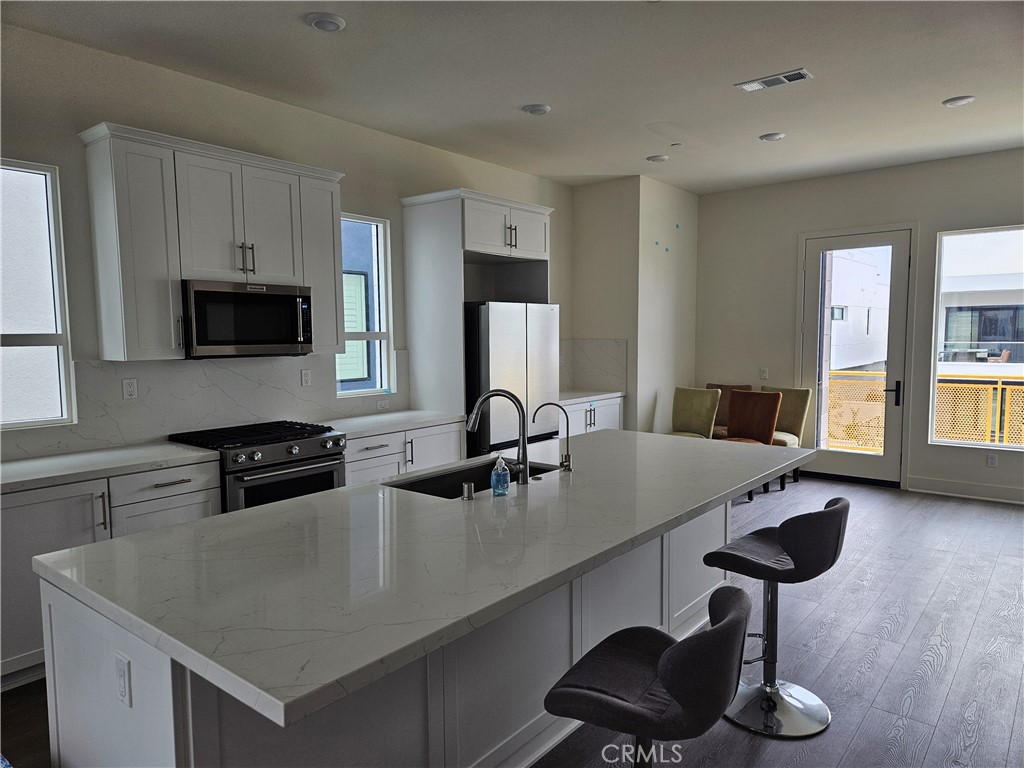 16238 Veterans Way Tustin, CA 92782 - Photo 7 of 8 a kitchen with a sink cabinets and wooden floor