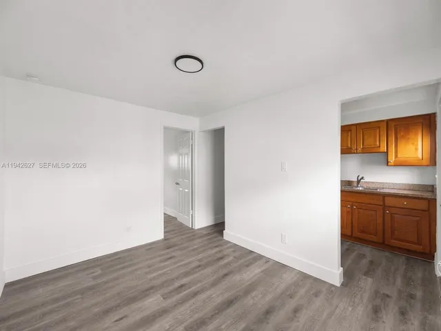 a view of a kitchen with a sink dishwasher and wooden floor