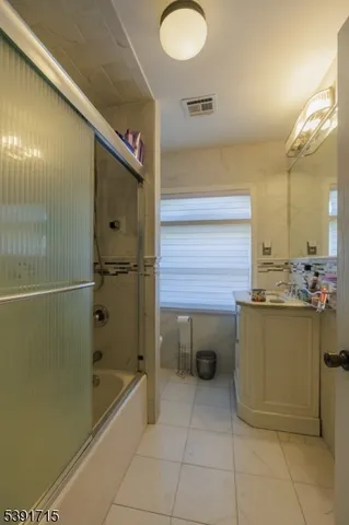 a bathroom with a tub sink and mirror