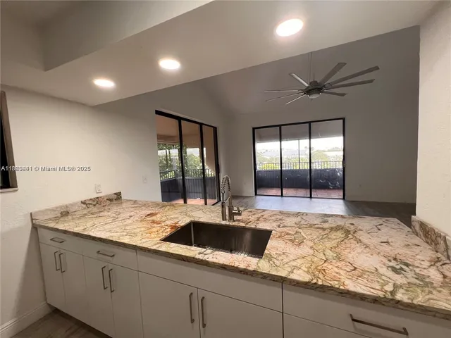a view of kitchen with sink and refrigerator