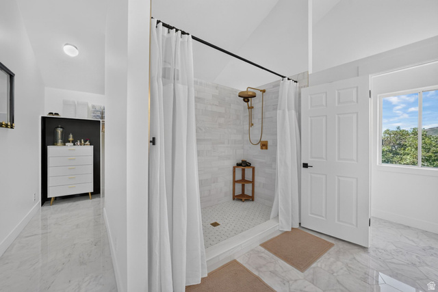 1979 Cave Hollow Way Bountiful, UT 84010 - Photo 28 of 59 Shower enclosure with brass-finish fixtures, white subway tile surround, and a coordinating pebble-tile floor