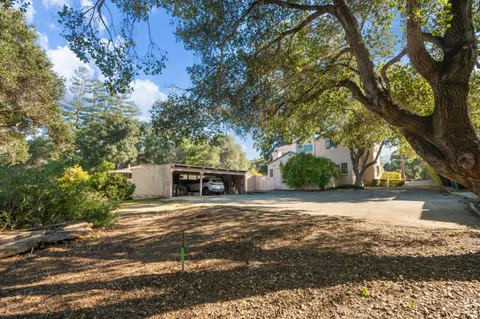 a view of a house with a yard and tree