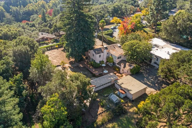 an aerial view of residential house with outdoor space and trees all around