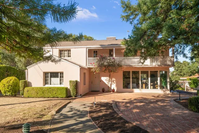 a front view of a house with a yard and potted plants