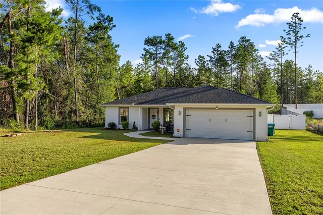 a front view of a house with a yard and trees