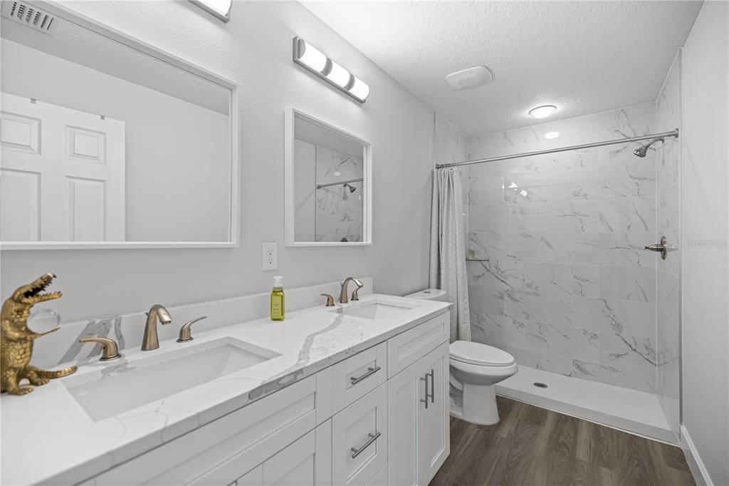 8607 Southwest 135th Street Road Ocala, FL 34473 - Photo 12 of 30 a bathroom with a double vanity sink toilet and shower