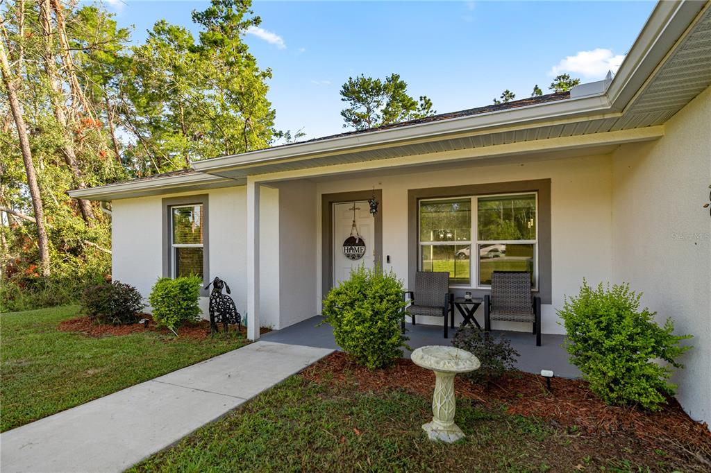 8607 Southwest 135th Street Road Ocala, FL 34473 - Photo 3 of 30 a view of a chair and table in backyard of the house