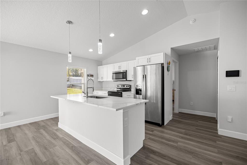 8607 Southwest 135th Street Road Ocala, FL 34473 - Photo 6 of 30 a kitchen with stainless steel appliances a refrigerator and a stove top oven