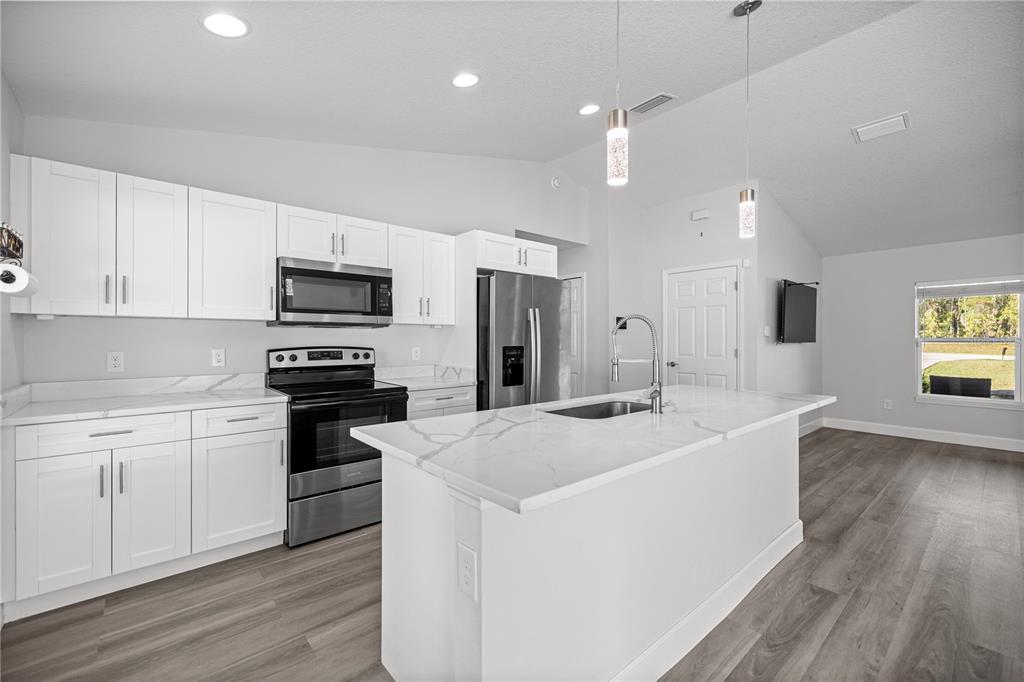 8607 Southwest 135th Street Road Ocala, FL 34473 - Photo 7 of 30 a kitchen with stainless steel appliances a sink stove and refrigerator