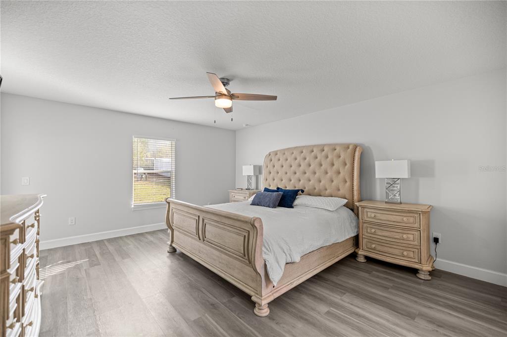 8607 Southwest 135th Street Road Ocala, FL 34473 - Photo 9 of 30 a bedroom with a bed lamp and a window