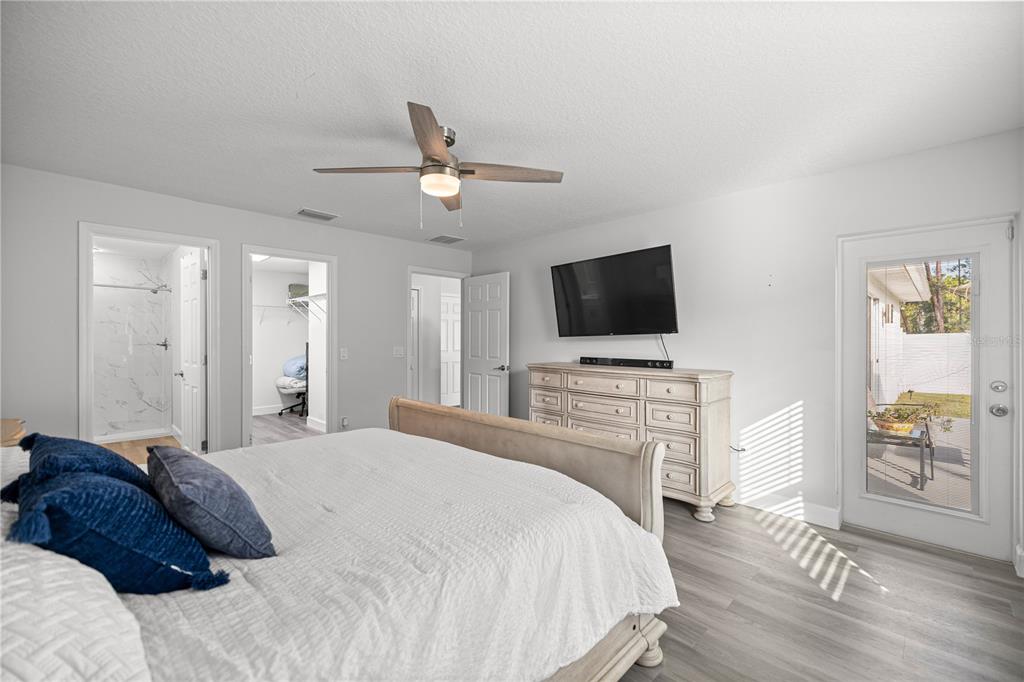 8607 Southwest 135th Street Road Ocala, FL 34473 - Photo 10 of 30 a spacious bedroom with a bed and a flat screen tv