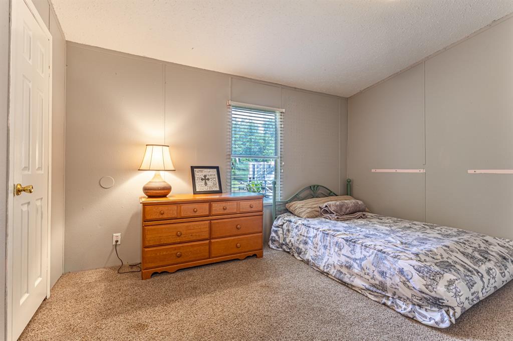 75 Southern Road Mineral Wells, TX 76067 - Photo 26 of 31 a bedroom with a bed and a lamp on desk