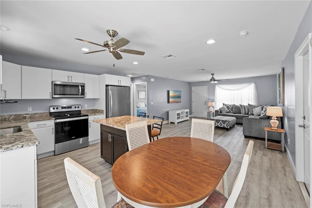 17528 Fuchsia Road Fort Myers, FL 33967 - Photo 13 of 42 a kitchen with sink a refrigerator and chairs