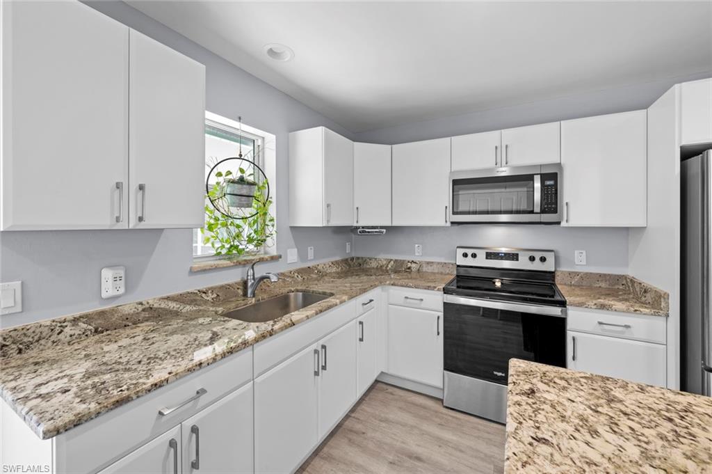 17528 Fuchsia Road Fort Myers, FL 33967 - Photo 15 of 42 a kitchen with granite countertop a sink cabinets stainless steel appliances and a window