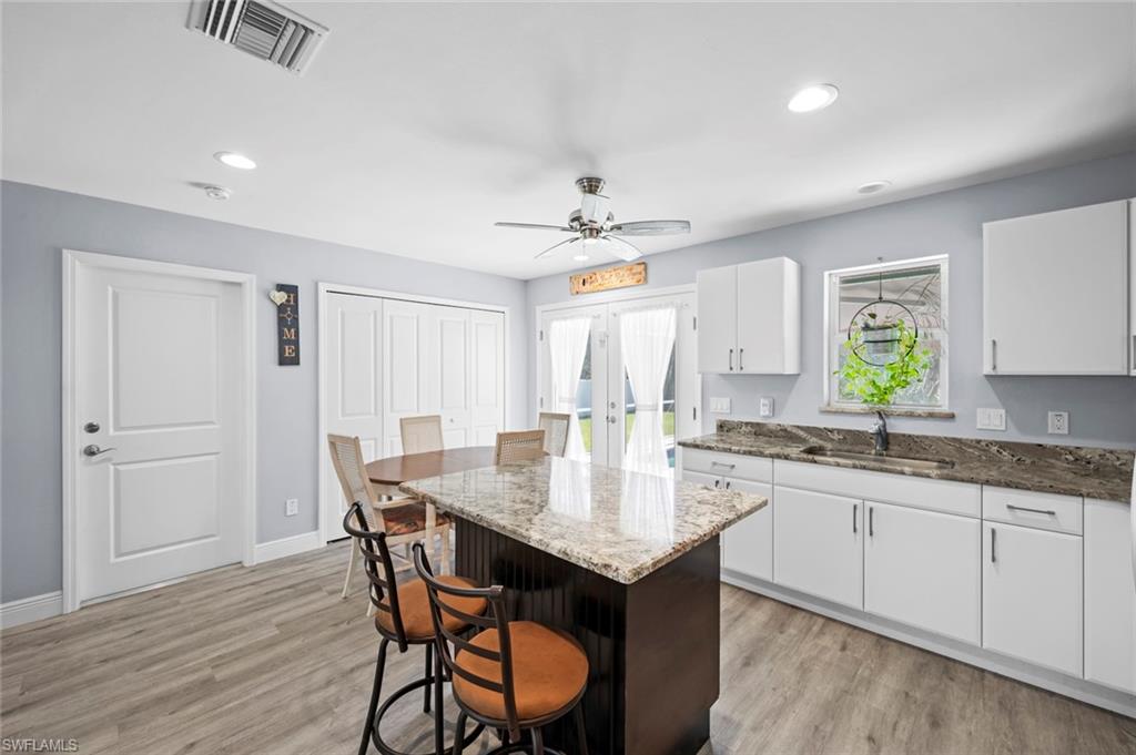 17528 Fuchsia Road Fort Myers, FL 33967 - Photo 17 of 42 a kitchen with granite countertop a sink cabinets and wooden floor