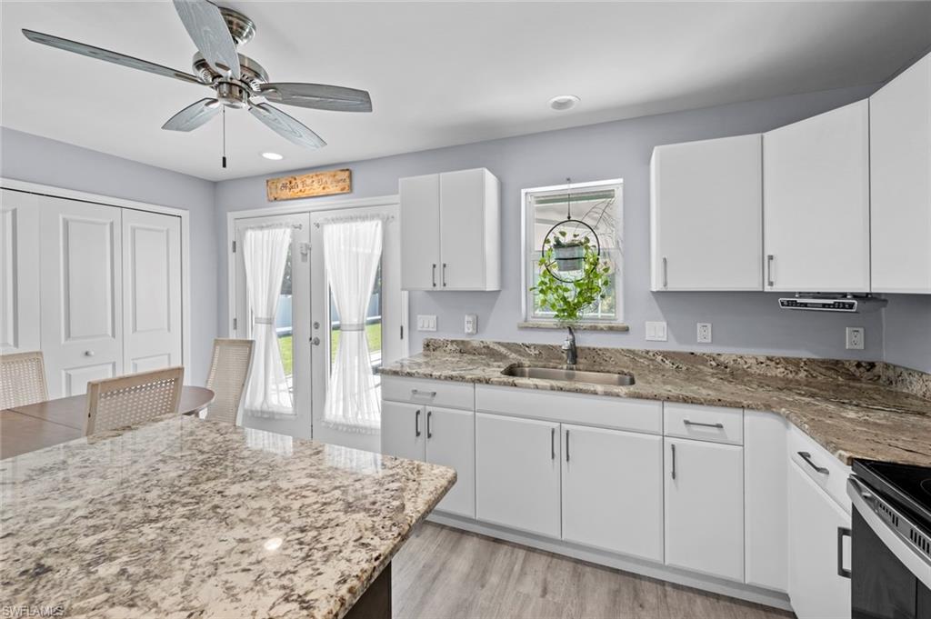 17528 Fuchsia Road Fort Myers, FL 33967 - Photo 19 of 42 a kitchen with a stove a sink a refrigerator and chandelier