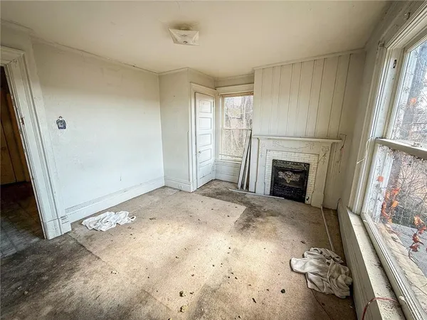 a view of empty room with fireplace and wooden floor