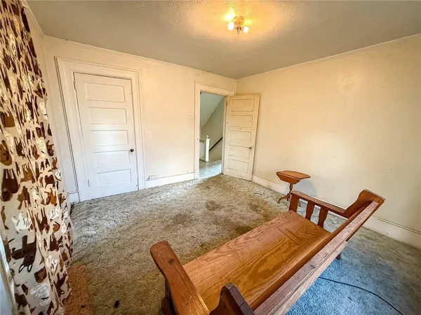 a view of a hallway with two chairs and a potted plant