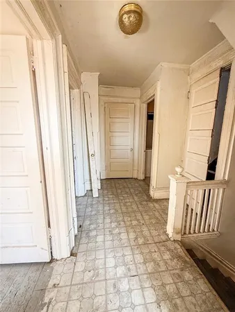 an empty room with wooden floor closet and windows