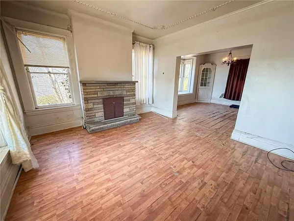 an empty room with windows and fireplace