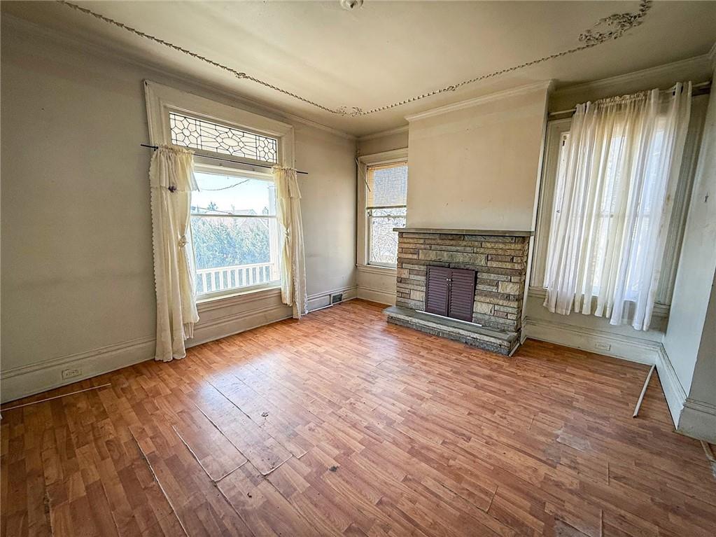 248 East Fulton Street Butler, PA 16001 - Photo 8 of 35 an empty room with wooden floor fireplace and windows