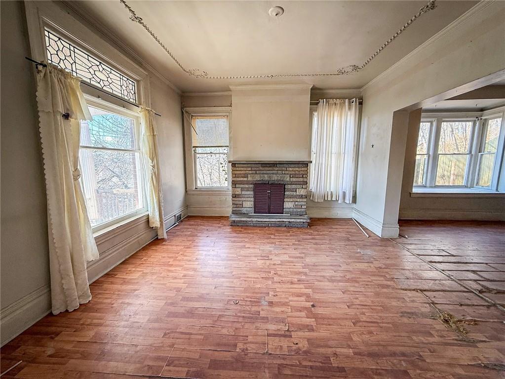 248 East Fulton Street Butler, PA 16001 - Photo 9 of 35 an empty room with windows fireplace and wooden floor