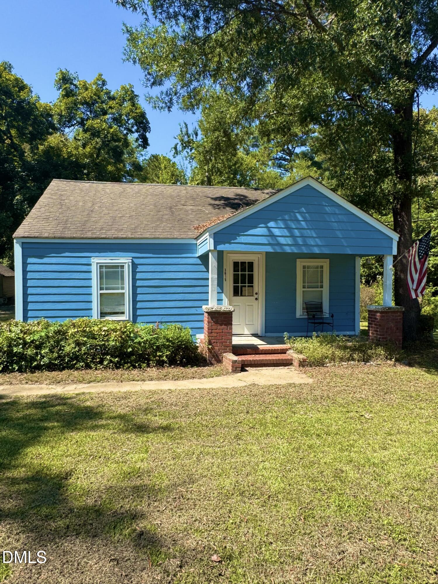 a front view of a house with a garden and yard