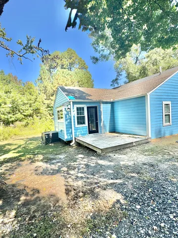 a view of a house with a patio and a yard