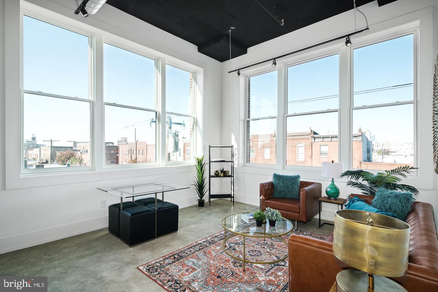 a living room with furniture fireplace and a large window