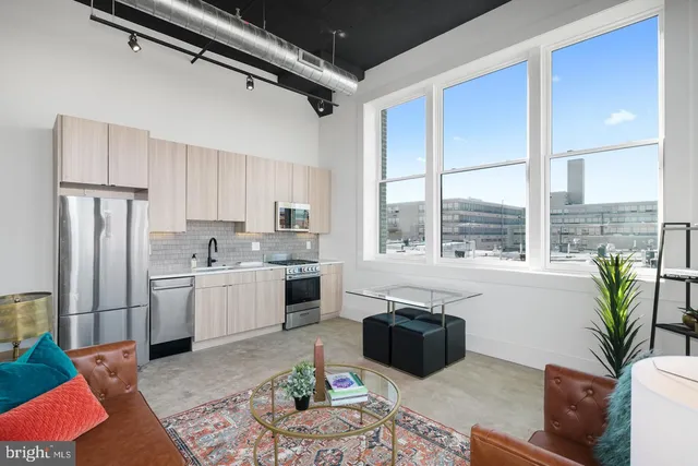 a kitchen with stainless steel appliances granite countertop a refrigerator a sink dishwasher and white cabinets with wooden floor