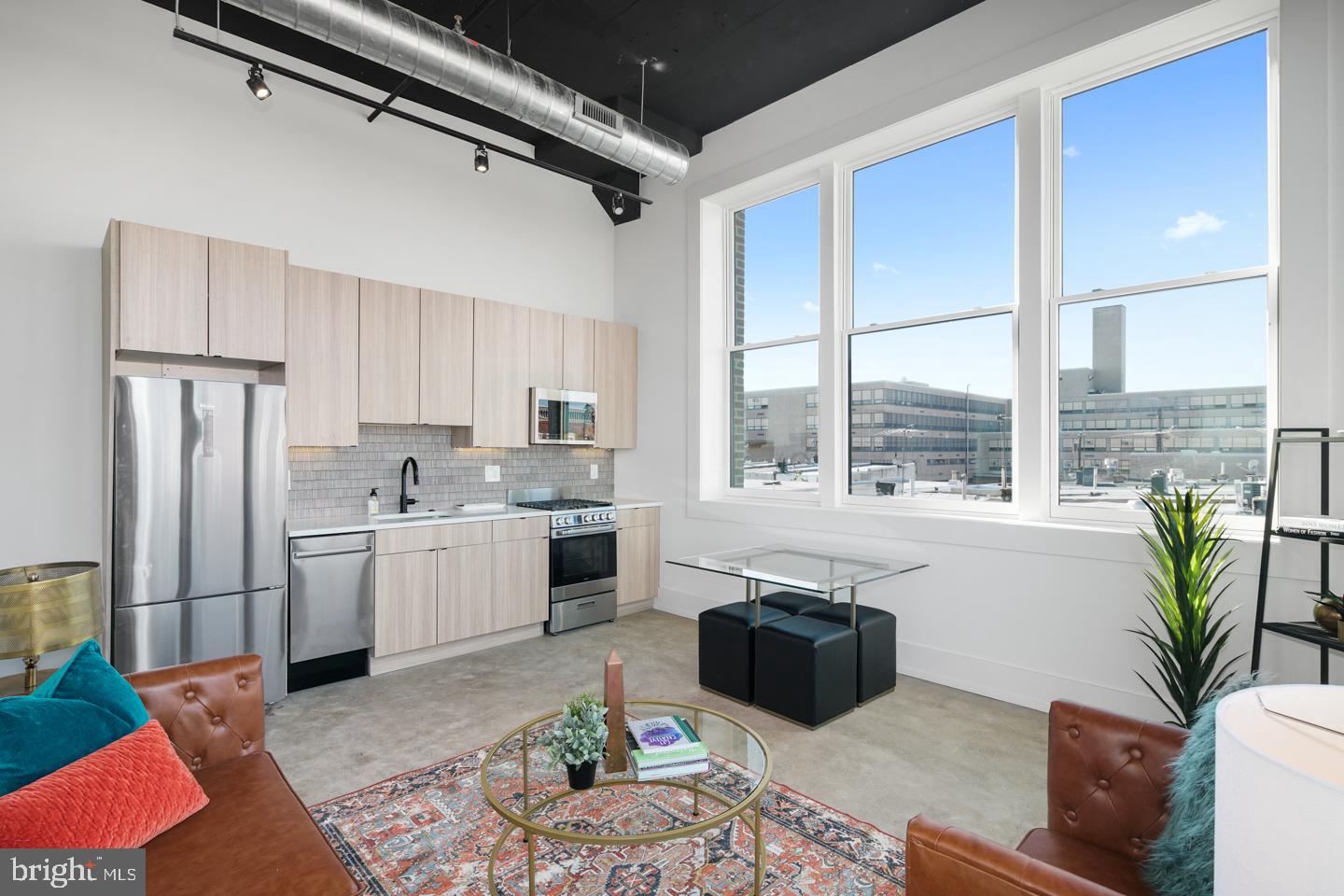 1218 Snyder Avenue, Unit 5 Philadelphia, PA 19148 - Photo 3 of 10 a kitchen with stainless steel appliances granite countertop a refrigerator a sink dishwasher and white cabinets with wooden floor