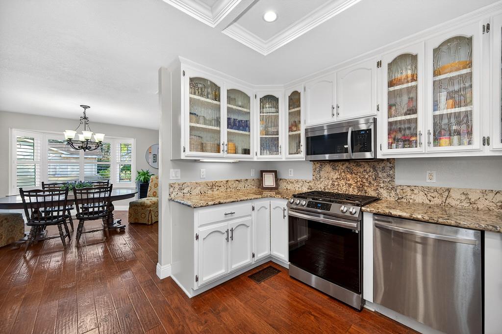 6610 Rio Oso Drive Rancho Murieta, CA 95683 - Photo 18 of 58 a kitchen with stainless steel appliances granite countertop a stove and a wooden cabinets