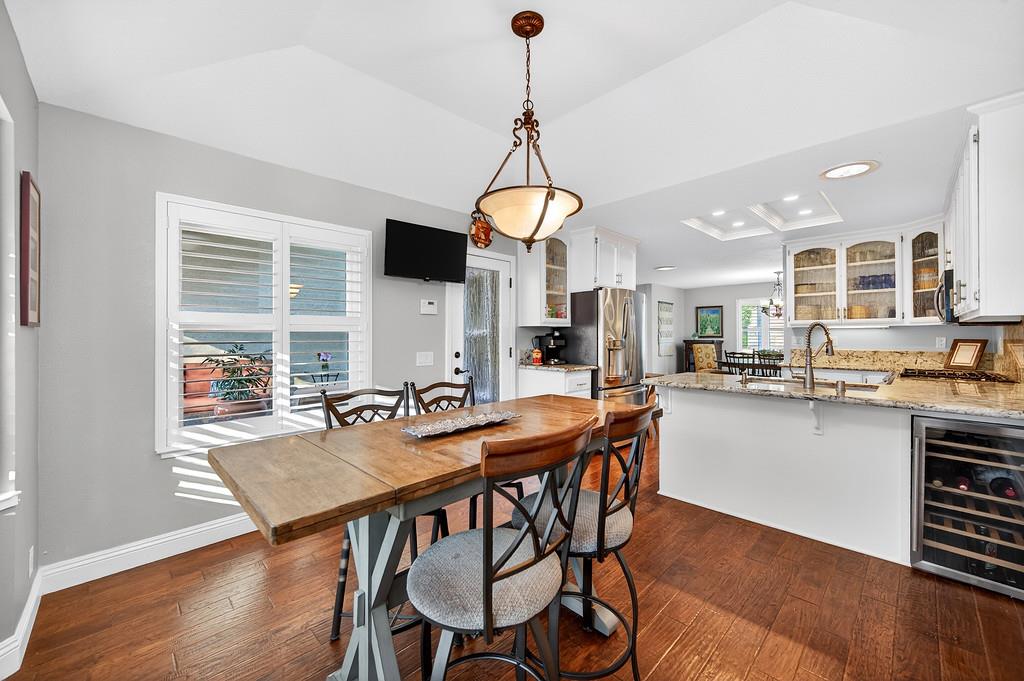 6610 Rio Oso Drive Rancho Murieta, CA 95683 - Photo 22 of 58 a dining room with wooden floor a chandelier a wooden table and chairs