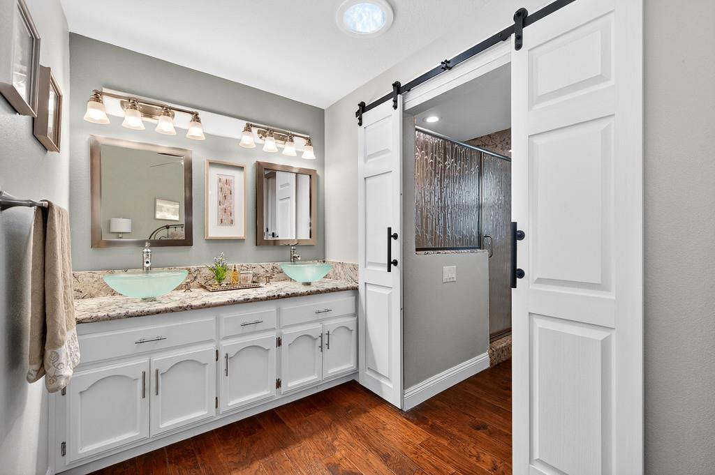 6610 Rio Oso Drive Rancho Murieta, CA 95683 - Photo 36 of 58 a bathroom with a granite countertop sink and a mirror