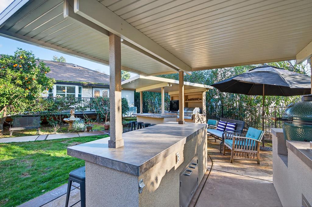 6610 Rio Oso Drive Rancho Murieta, CA 95683 - Photo 57 of 58 a patio with a table and chairs under an umbrella