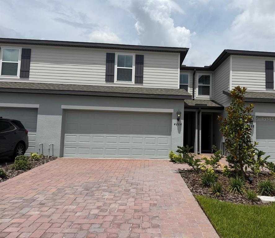 4264 Ranch House Road St. Cloud, FL 34772 - Photo 1 of 34 a front view of a house with a yard and garage